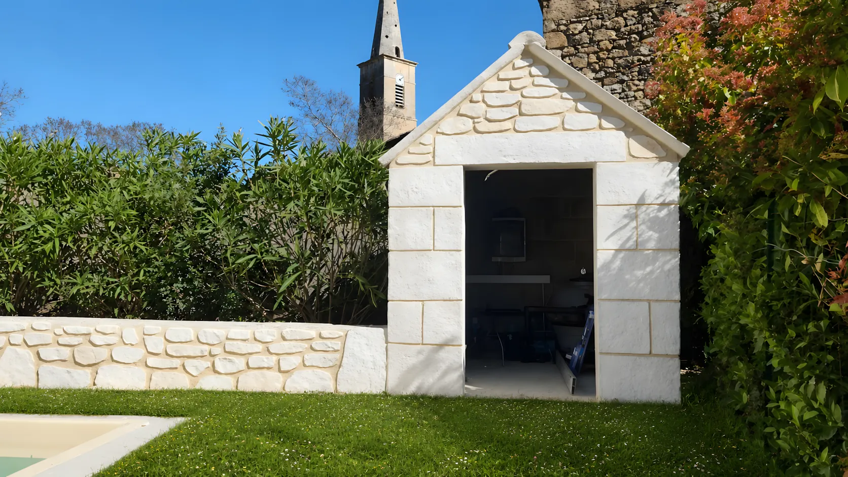 Le même cabanon après : pierres sculptées dans l’enduit à la chaux, chaînage d’angle et clocher du village en arrière-plan